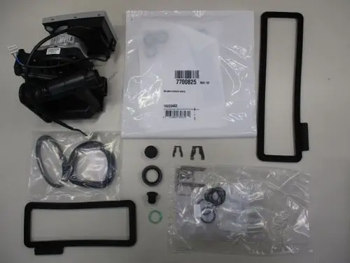 Remeha Hydroblock mit Pumpe, ergänzt durch verschiedene Dichtungen und Befestigungselemente, angeordnet auf hellem Tisch.